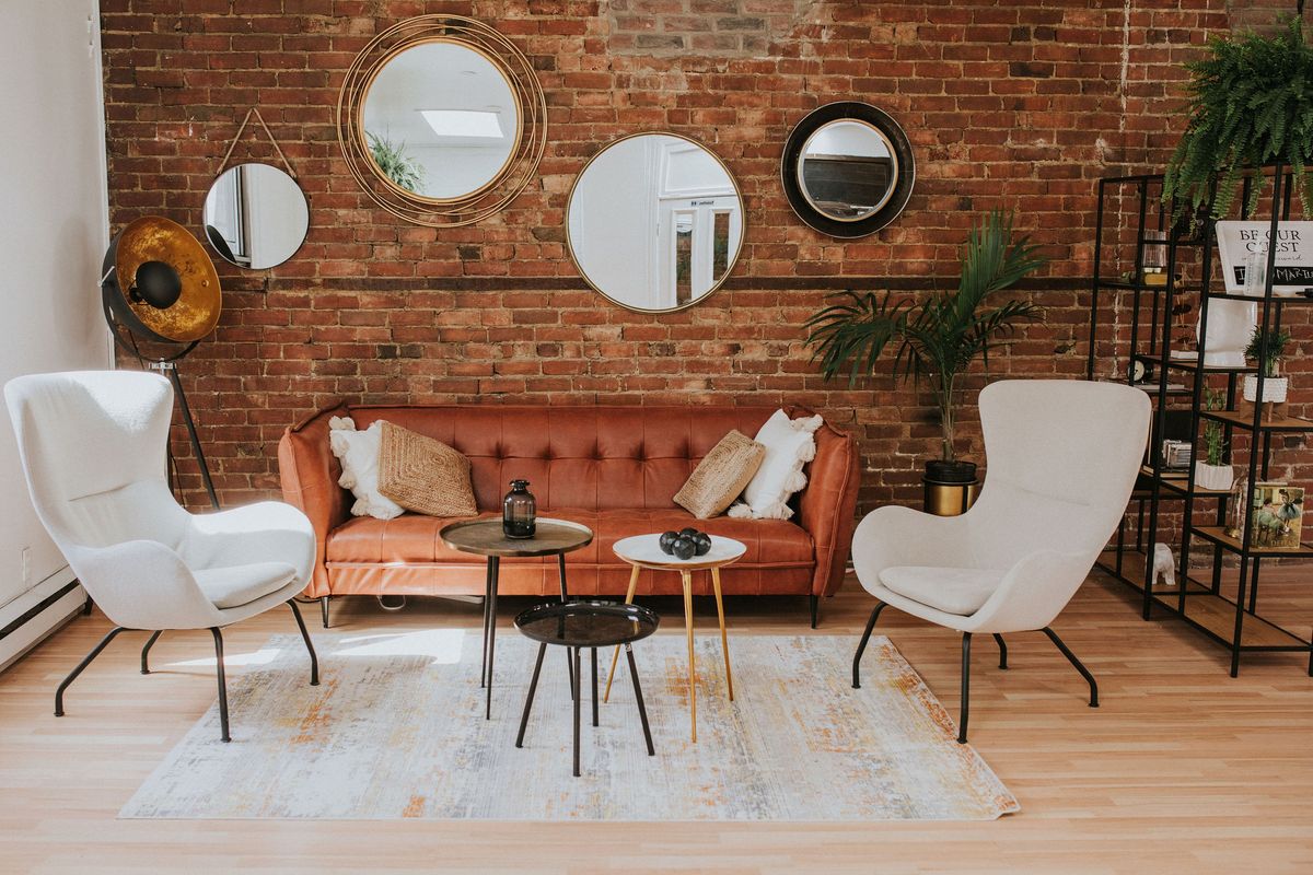 Le loft : brique apparente, mur de miroirs et coin salon velours